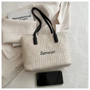 Détail du sac cabas en paille tressée avec broderie Summer noire et anses en cuir