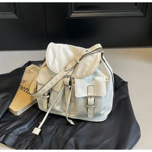 Detail view of white nylon canvas bag featuring dual buckle pockets and adjustable straps