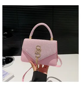 Détail du sac à bandoulière rose avec rabat en strass et logo SS en métal doré