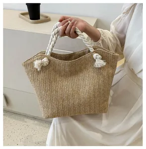 Close-up of hand-woven straw tote bag with herringbone texture and soft cotton rope handles