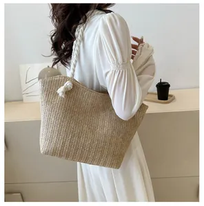 Detail view of woven straw tote bag featuring white rope handles and chevron knit texture