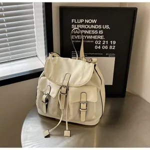 Detail of cream canvas bag featuring functional pockets and drawstring flap closure