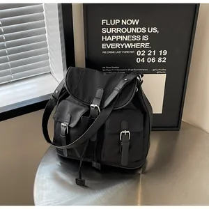 Detail of minimalist black nylon backpack with metal buckles and matte finish texture