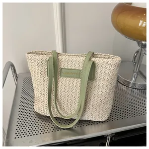 Detailed texture of straw tote bag featuring fashion letter patch and faux leather straps