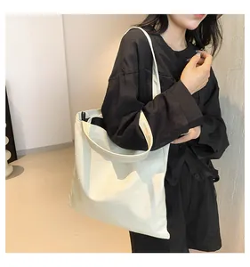 Close-up of cream tote bag featuring unique irregular patchwork texture and wide strap