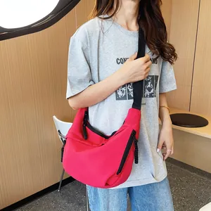 Close-up of bright red nylon dumpling bag featuring black adjustable shoulder strap