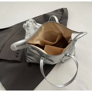 Macro view of metallic silver tote interior with zipper pocket and spacious lining