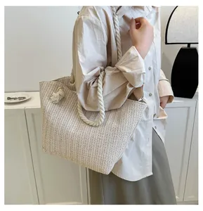 Detail of hand-woven straw tote bag with cotton rope handles and beige texture