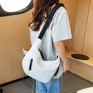Detailed view of white nylon crossbody tote bag with black strap and woven zipper pull