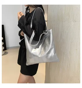 Close-up of metallic silver tote bag with geometric square texture and sleek shoulder straps
