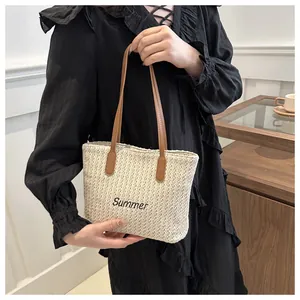 Détail de la broderie Summer sur un sac cabas en paille porté par un mannequin