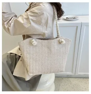 Detail of woven straw tote bag with chunky cotton rope straps and stylish knot accents