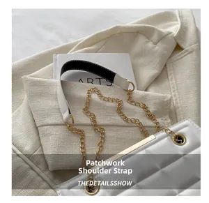 Detalle de bolso acolchado blanco con cadena dorada y correa de hombro pespunteada