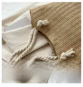 Detail of woven straw tote bag featuring herringbone texture and thick rope handles
