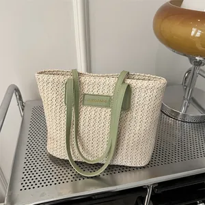 Chic woven tote bag with light green leather straps and a minimalist brand patch