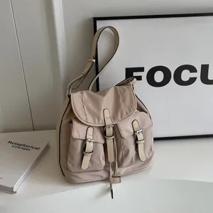 Beige canvas backpack with three front pockets and retro leather buckle details