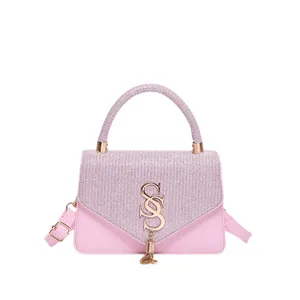 Sac bandoulière rose avec rabat pailleté et boucle dorée en forme de S à pompon