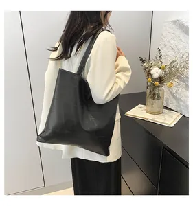 Macro detail of black tote bag featuring modern geometric patchwork texture and PU finish