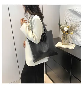 Detail of black tote bag with geometric textured surface shown on a model for daily use