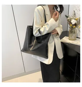 Close-up of black tote bag featuring geometric embossing and white contrast stitching