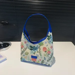 Floral hobo shoulder bag in off-white jacquard fabric with vibrant blue handles and trim