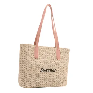 Sac fourre-tout en paille d'été avec anses roses et broderie sur fond blanc épuré
