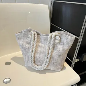 Minimalist beige woven straw tote bag with cotton rope handles and herringbone pattern