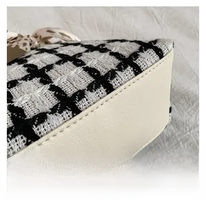 Detail van tweed ruitpatroon met nauwkeurig stikwerk en decoratieve zijden sjaal