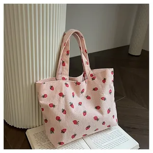 Détail du sac fourre-tout en velours côtelé rose avec imprimé fraise et texture