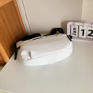 Detail shot of a white sports crossbody bag with black adjustable strap and cord zipper