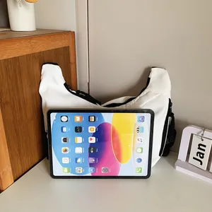 White minimalist crossbody bag shown with a tablet to demonstrate large storage capacity