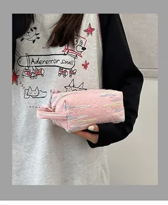 Detail van roze gewatteerde make-up tas met kleurrijk stiksel en een handvat bovenop