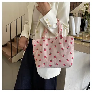 Détail du sac cabas rose en velours côtelé avec motifs fraises et texture douce