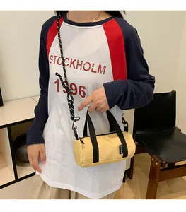 Mini yellow cylinder crossbody bag with black rope strap and durable nylon fabric texture
