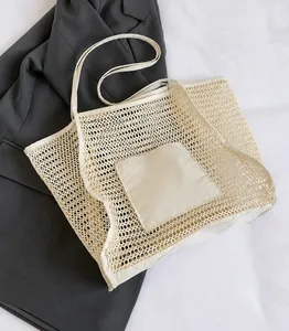 Close-up of large beige mesh beach bag with internal pouch on a white background