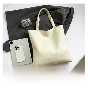 Detail of cream leather patchwork tote bag with long handles in a modern lifestyle setting