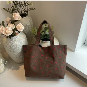 Sac fourre-tout en velours côtelé marron à imprimé fraises sur table blanche