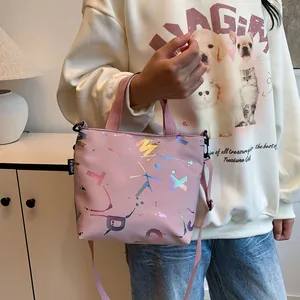 Detailed side view of pink crossbody bag with laser lettering and brand tag