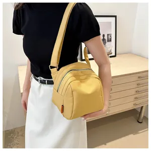 Dettaglio della borsa a tracolla in nylon giallo con tracolla regolabile indossata