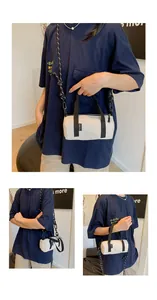 Detailed view of mini cylinder crossbody bag in cream canvas with woven shoulder strap