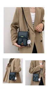 Detail of crossbody phone bag with black pattern, fashion text and plush monster charm