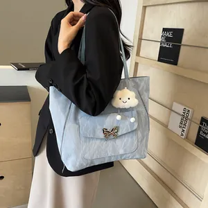 Detail of light blue pleated tote bag with butterfly metal buckle and cloud pendant