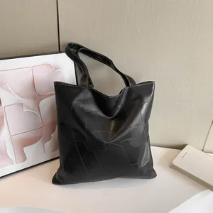 Chic black faux leather tote bag with geometric patchwork design and large capacity