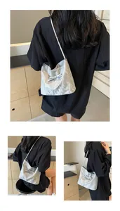 Sac sous le bras argenté avec texture plissée et nœud porté par un mannequin