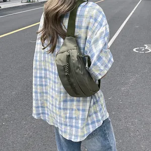 Olive green nylon crossbody bag with embossed lettering and braided zipper pull
