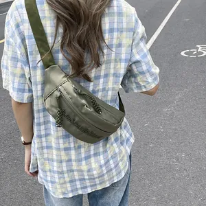 Outdoor close-up of army green waterproof nylon crossbody chest bag with woven zipper puller