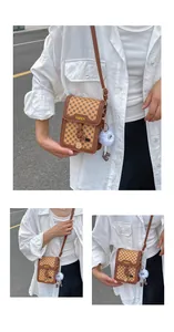 Detail of vintage brown monogram crossbody square bag with a cute fuzzy charm
