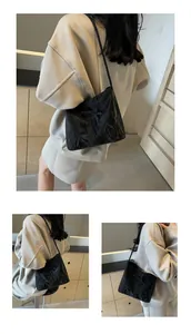 Détails d'un sac à bandoulière plissé noir avec nœud décoratif porté par un mannequin