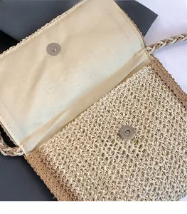 Detailed macro view of beige woven straw bag featuring magnetic metal buckle and inner lining