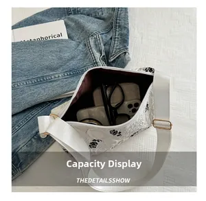 Internal view of floral embroidery bag showing capacity for phone, wallet and glasses